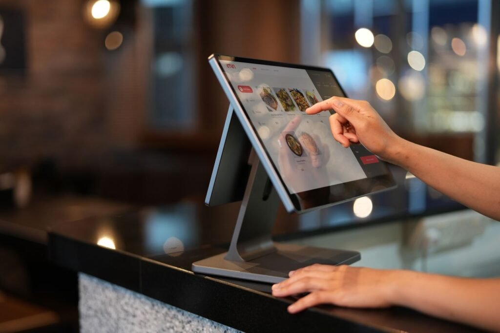 Crafting Captivating Headlines: Your awesome post title goes here Close-up of a hand interacting with a touchscreen POS system in a restaurant setting.