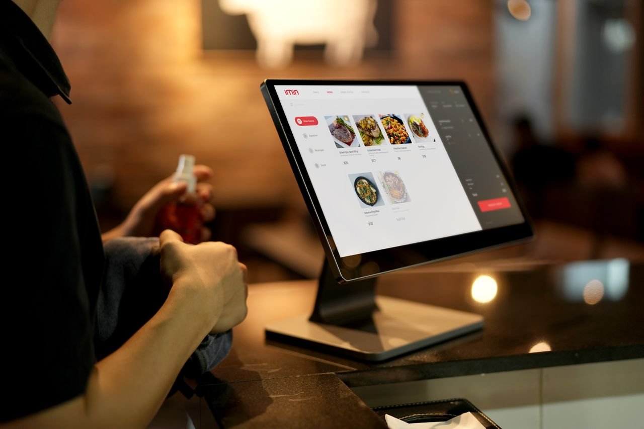 cta-01 A person using a touchscreen ordering system in a modern restaurant setting.