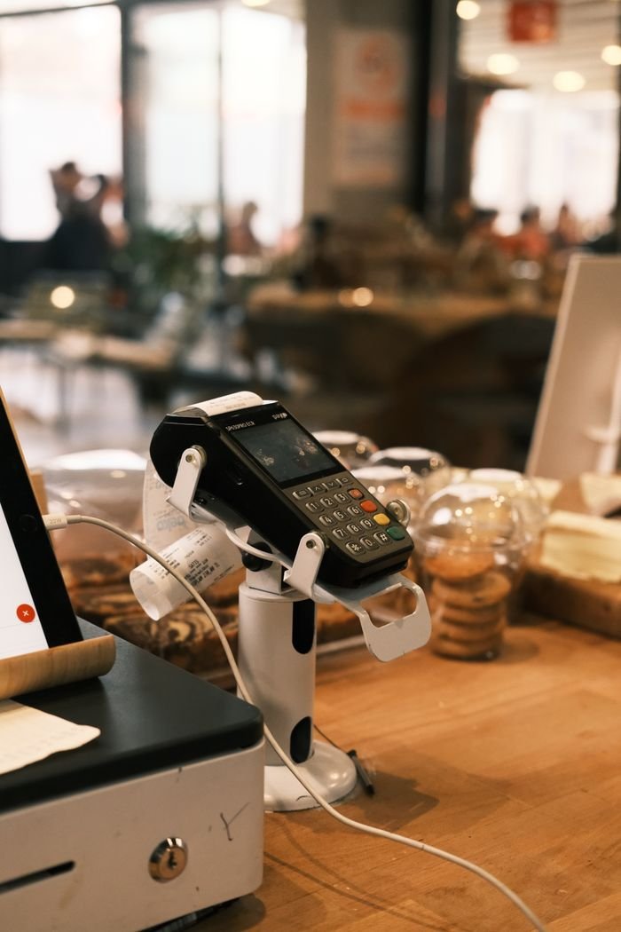 programs-01 A digital payment terminal on a cozy café counter, suggesting a modern lifestyle.