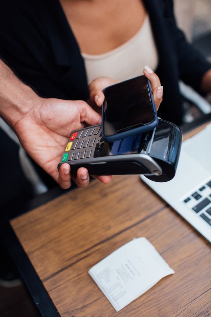 Mastering the First Impression: Your intriguing post title goes here Hands making a contactless mobile payment with a smartphone at a terminal.